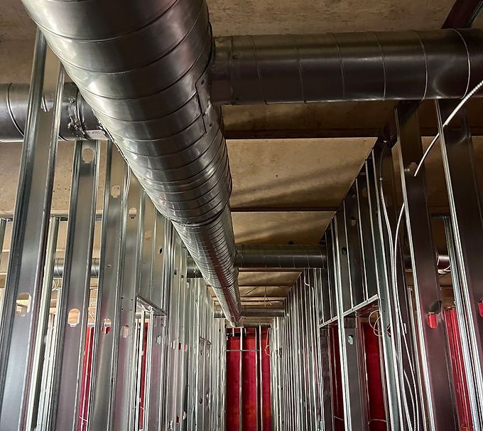 Construction framing and exposed ductwork in an unfinished building interior.
