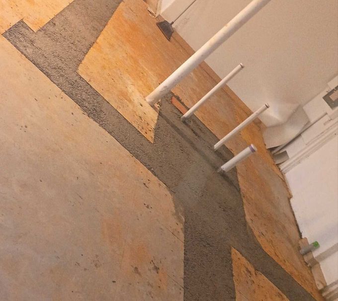 Empty indoor room with painted concrete floor and white railings along the wall