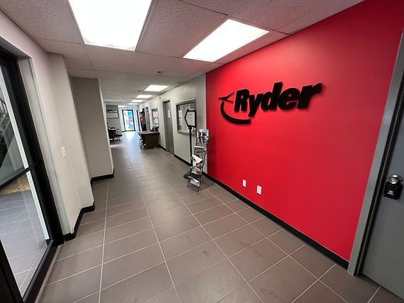 Office hallway with gray tile floor and a bright red Ryder wall logo.