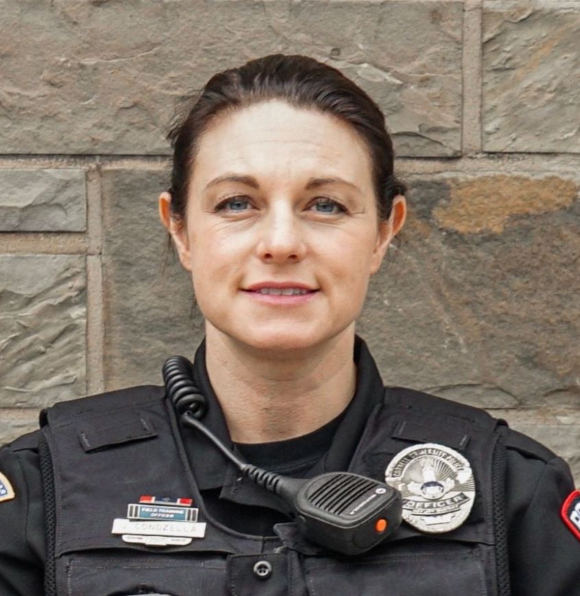 A woman in a police uniform with a microphone around her neck