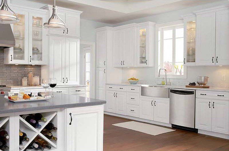 Bright white kitchen with island, stainless appliances, and large windows