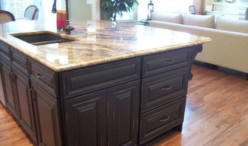 Dark wood kitchen island with a marble countertop in a bright room