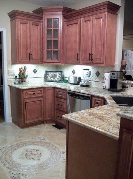 Warm-toned kitchen with wooden cabinets, granite counters, and stainless appliances
