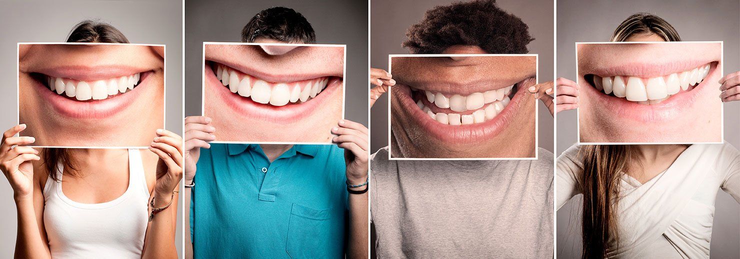 A group of people are holding pictures of their smiles in front of their faces.