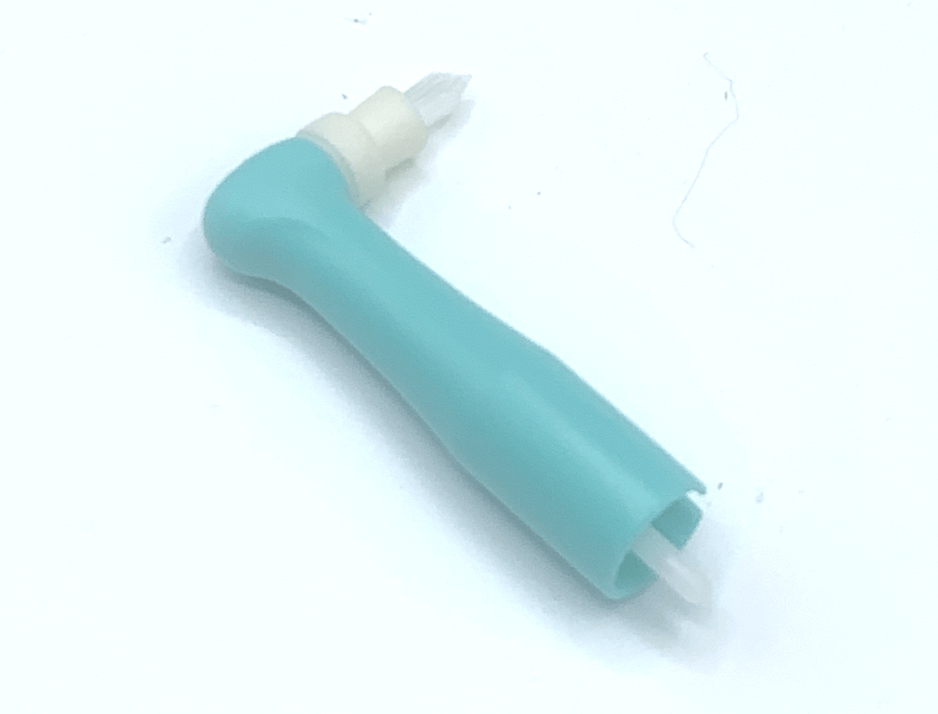 A blue and white toothbrush is sitting on a white surface.