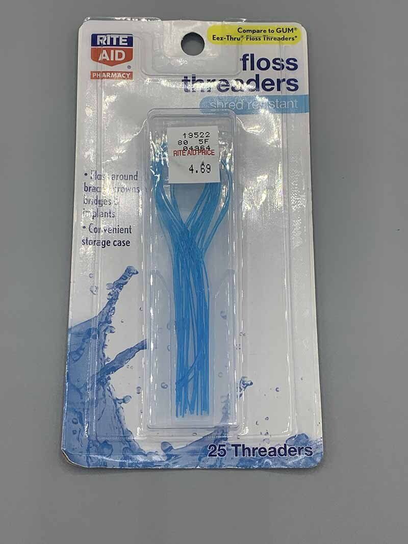 A package of floss threaders is sitting on a table.