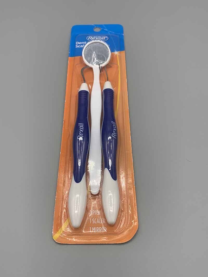 A dental mirror and toothbrush are in a package.