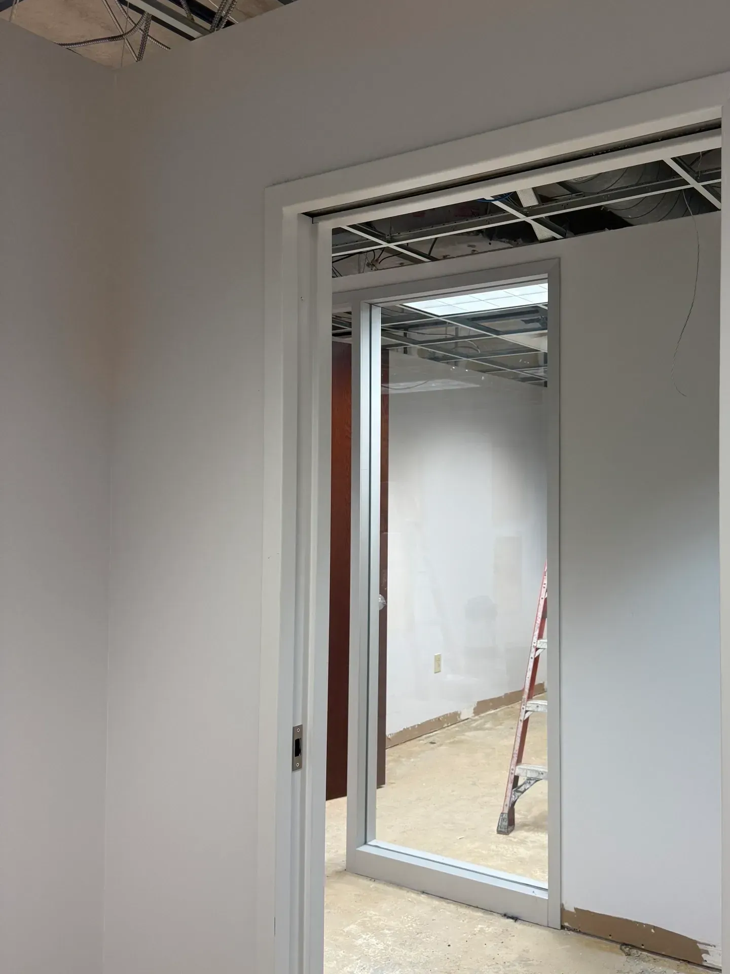 Partially finished interior doorway with white trim, opening to a room under construction