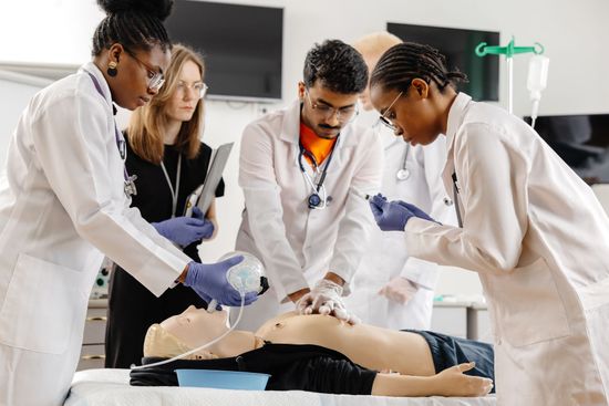 Medical students performing CPR on a training mannequin in a classroom lab