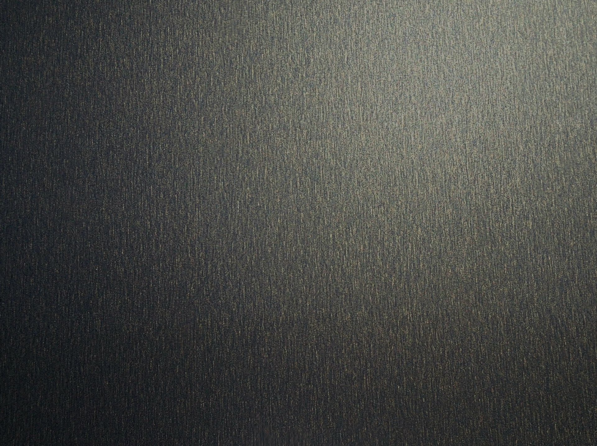 Dark gray, textured surface. Gradual light from right.