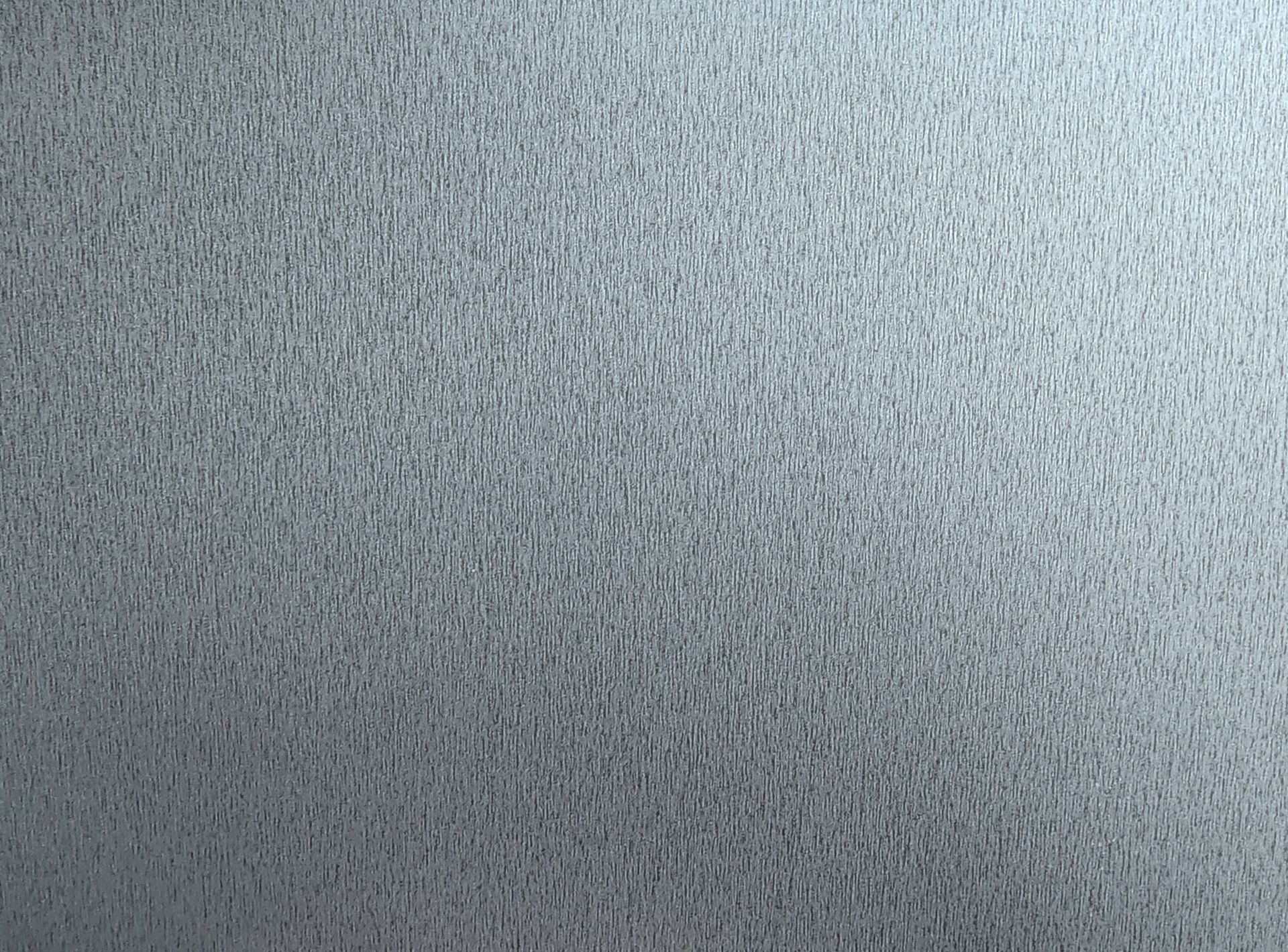 Textured silver surface with a slightly lighter area to the right.