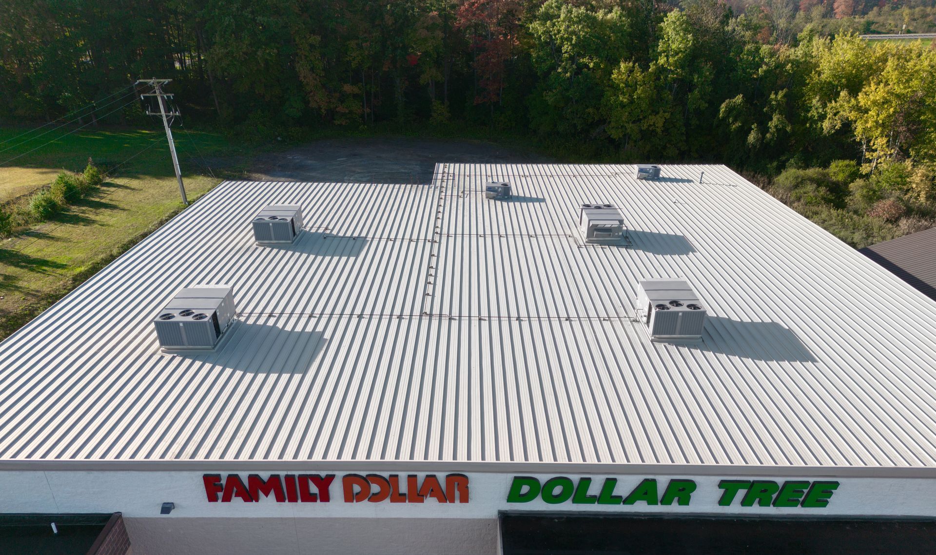 Aerial view of Family Dollar and Dollar Tree store with a metal roof and AC units.