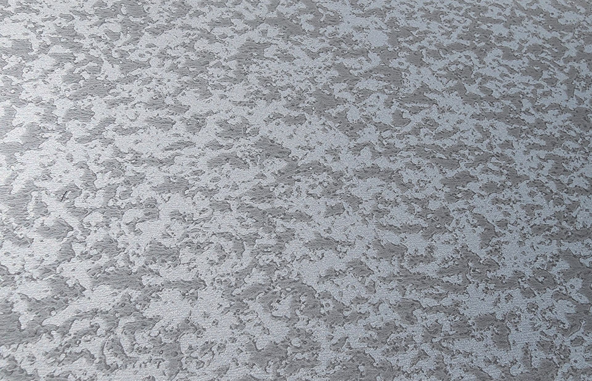 Textured gray surface with mottled, irregular pattern.
