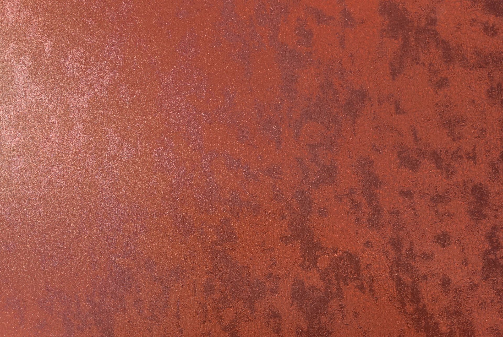 Red-brown textured surface with mottled darker areas, possibly rust or aged paint.