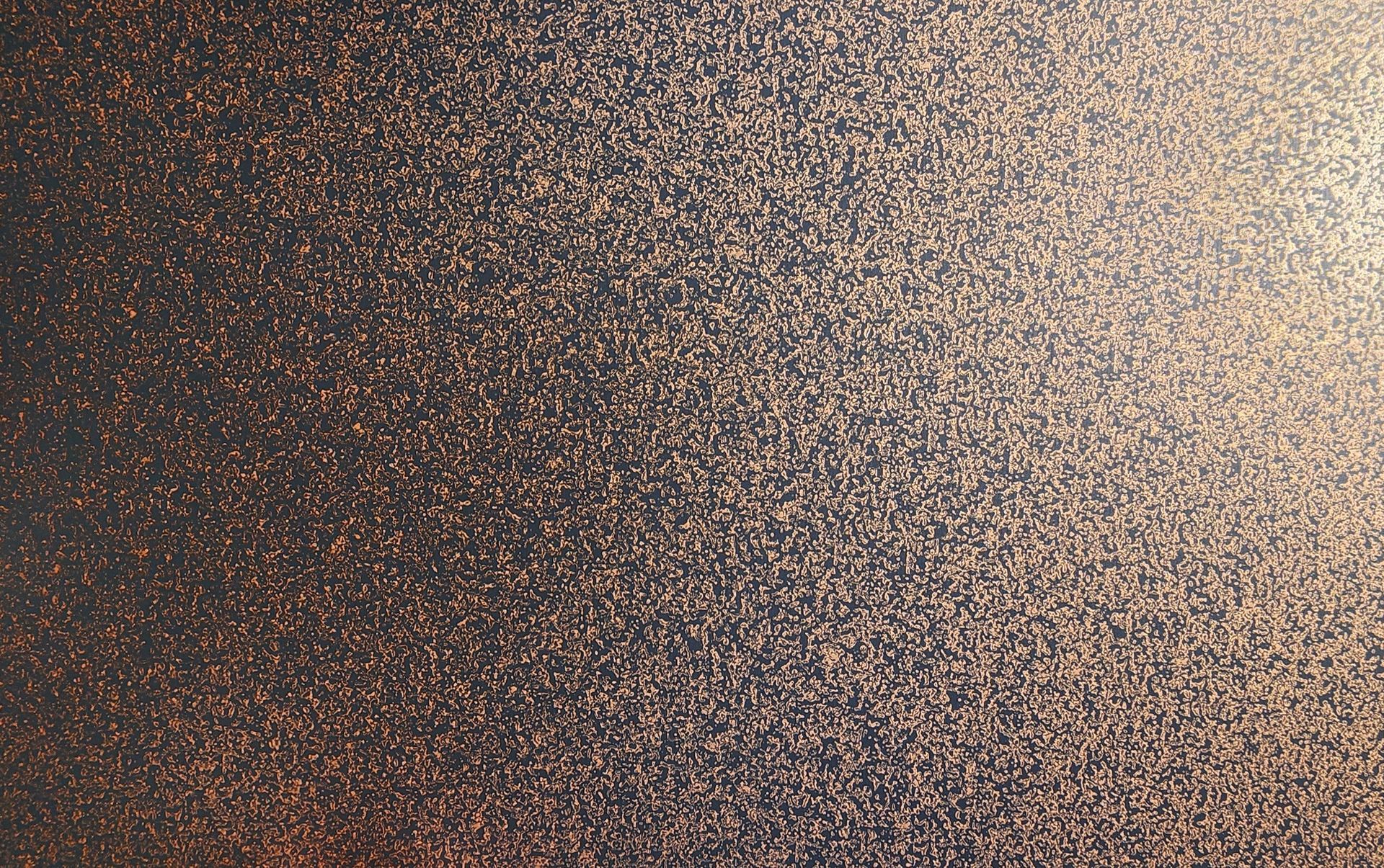 Dark surface with gold flecks, subtly lit, appears textured and shimmering.