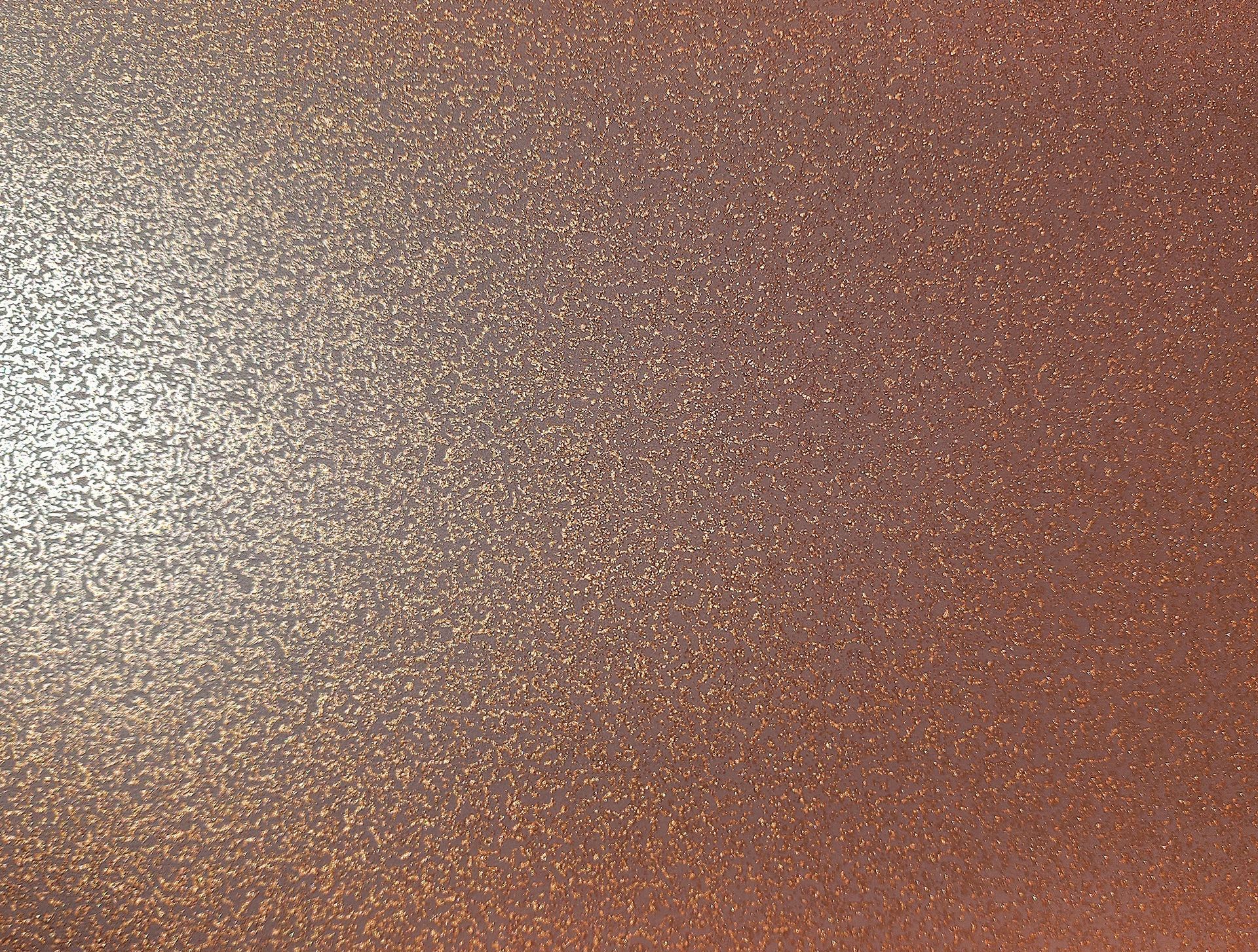 Glittering copper-colored surface, with light reflecting on the left.