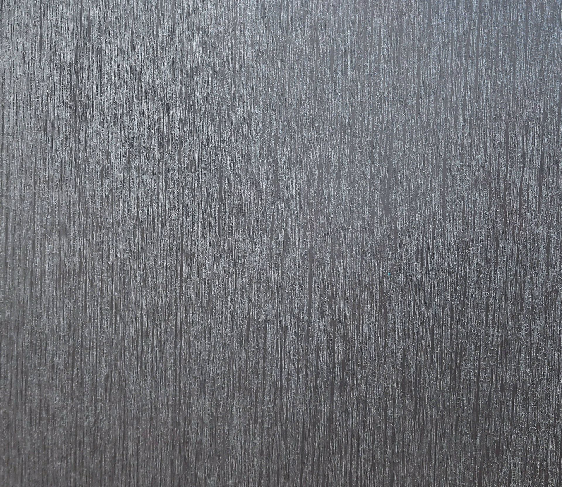 Textured, metallic surface with vertical, striated pattern.