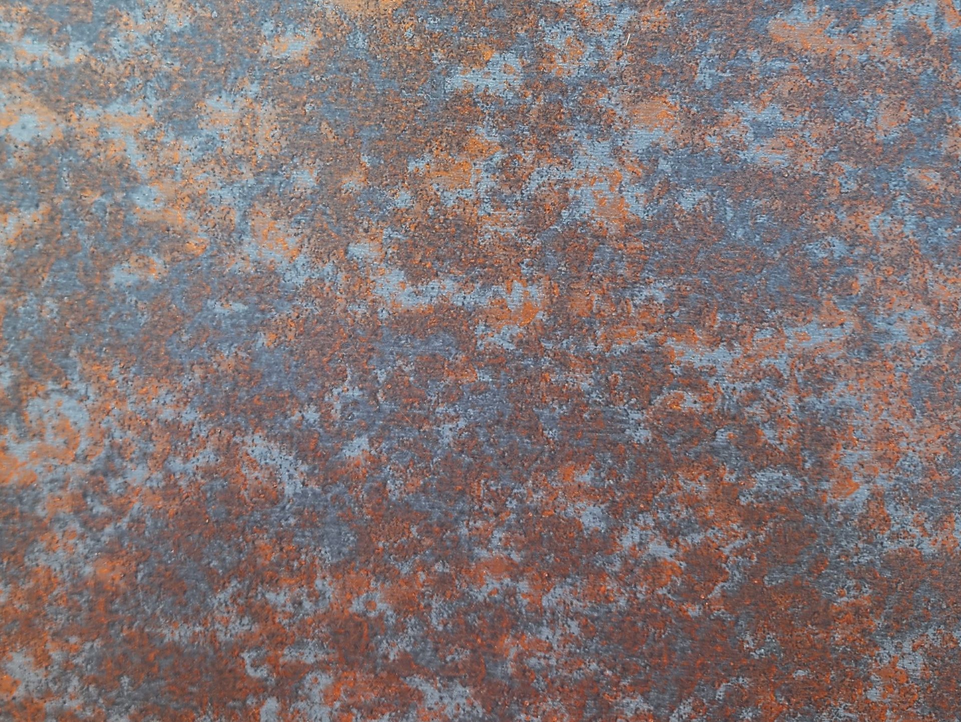 Textured surface of rust-colored and gray patterns, appearing mottled and aged.