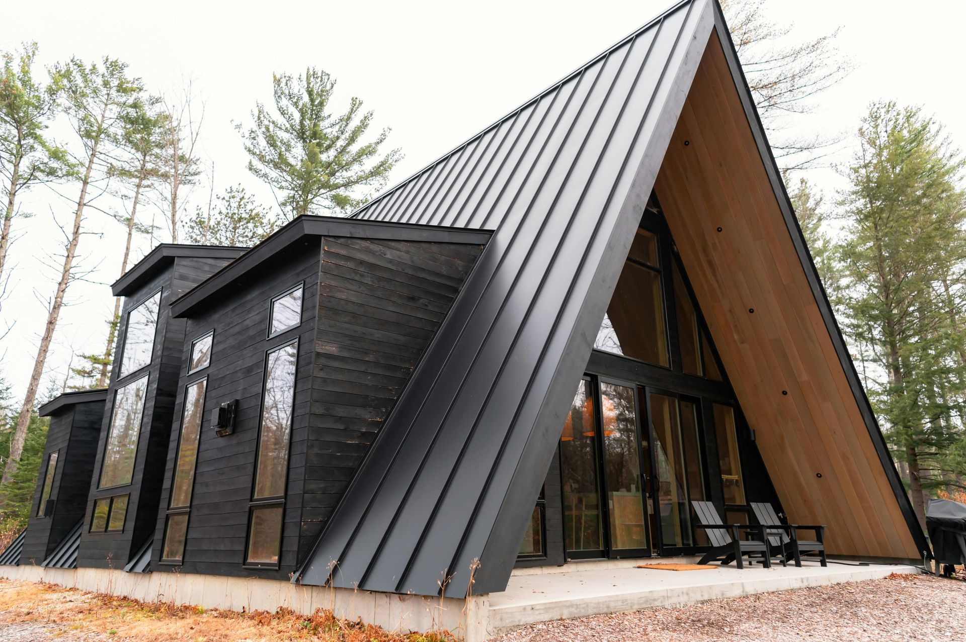 Modern black A-frame cabin with large glass walls in a wooded setting in Central PA