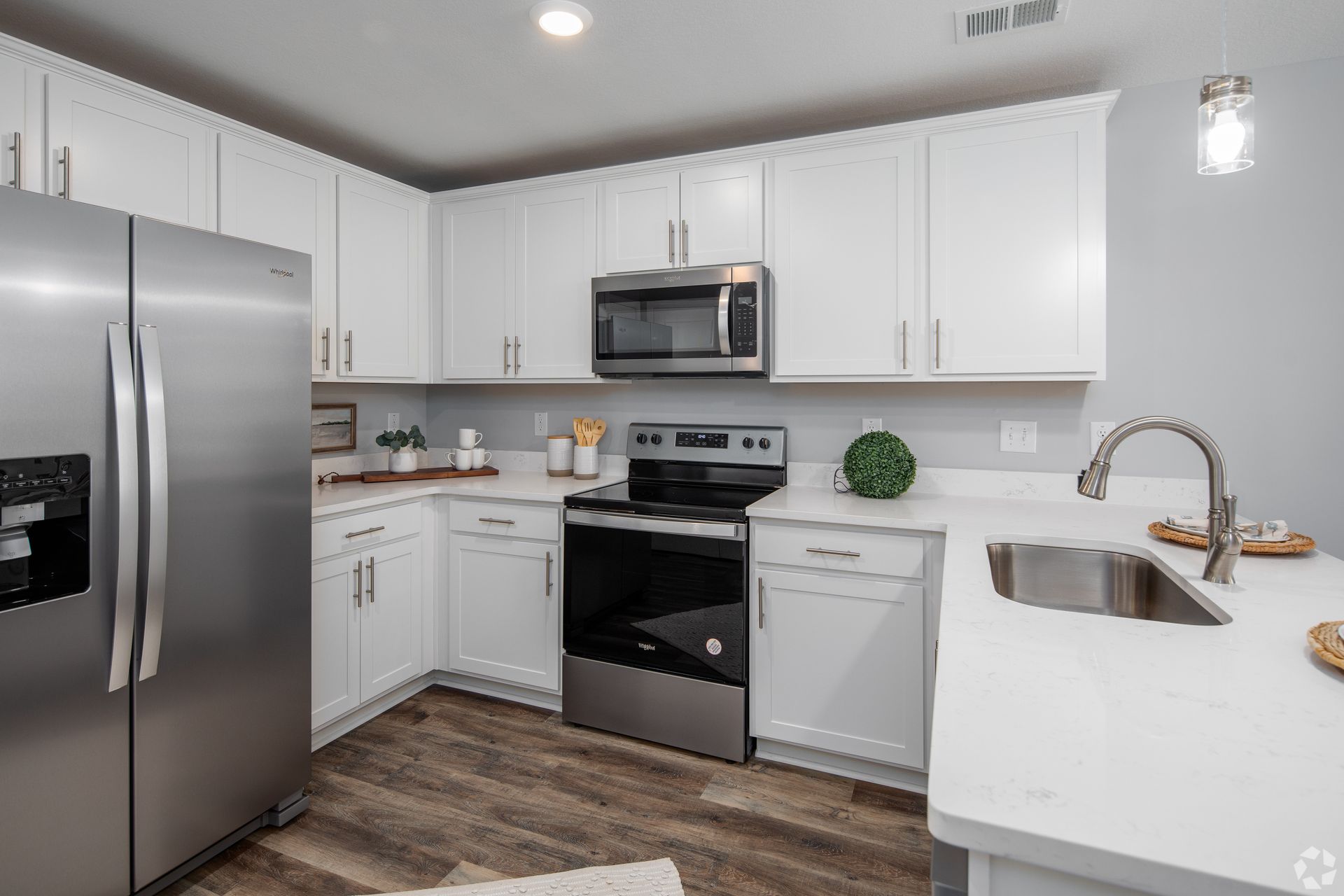 Modern kitchen with white cabinets, stainless steel appliances, and light-colored countertops.