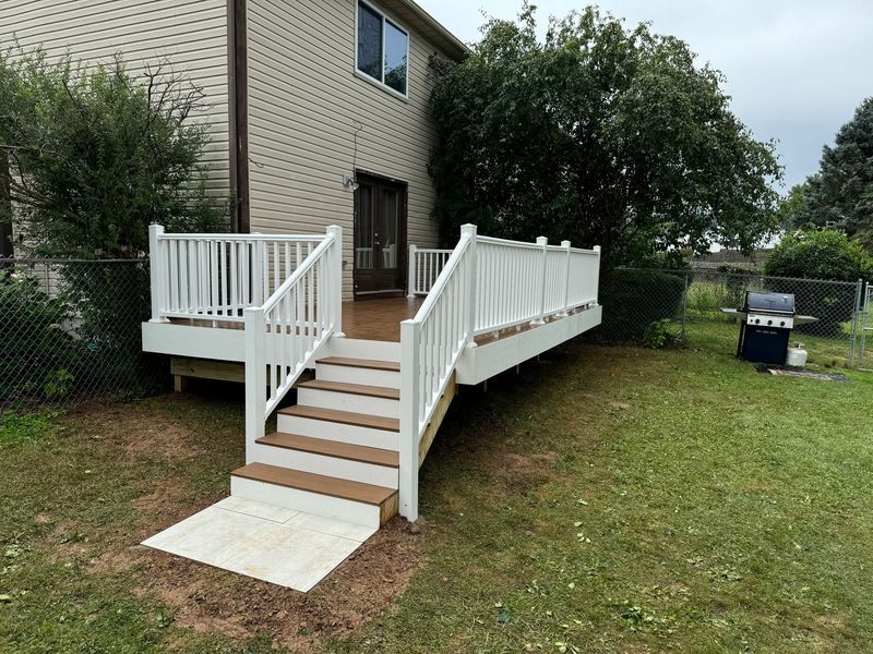 White wheelchair ramp with steps leading to a beige house in a grassy yard