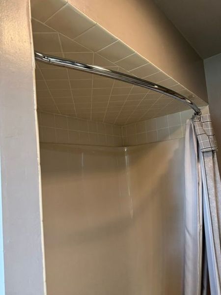 Empty closet with beige walls, wire shelving, and a hanging rod near the ceiling