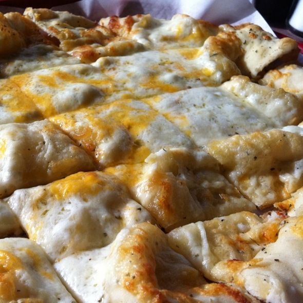 Close-up of cheesy baked bread with melted white and orange cheese on top