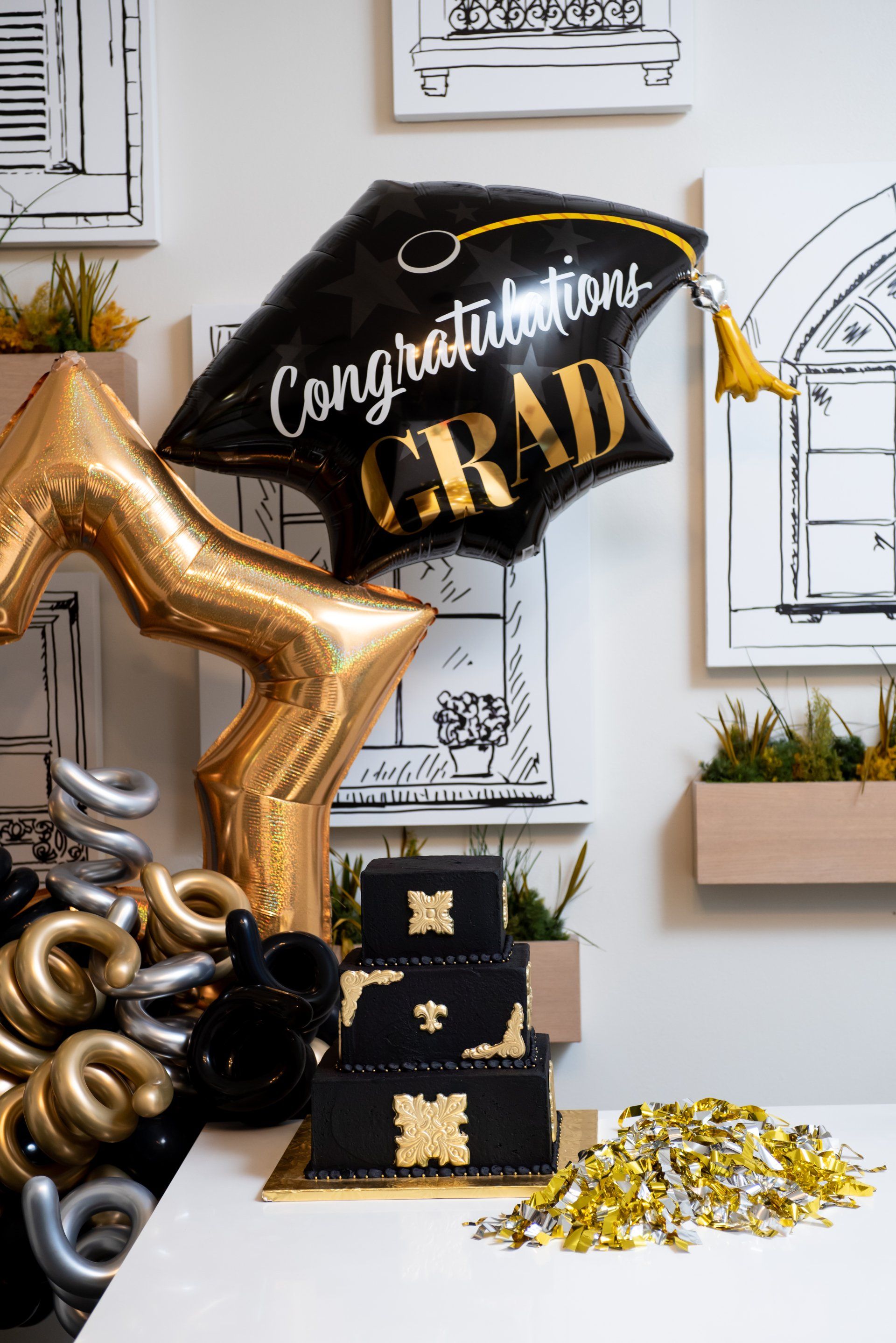 A graduation balloon is sitting on top of a cake on a table.