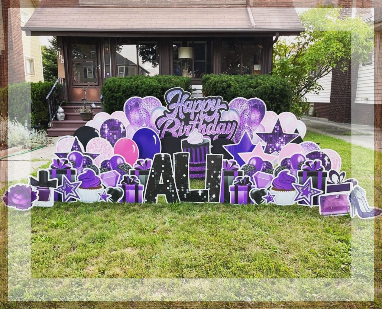 A purple and pink birthday sign is in front of a house.