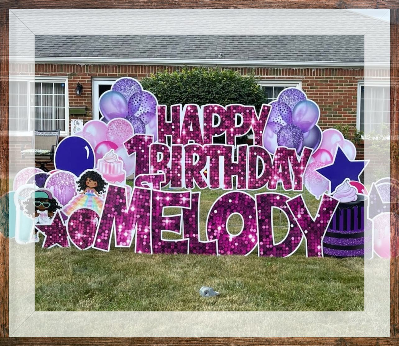 A framed picture of a happy birthday sign in front of a house.