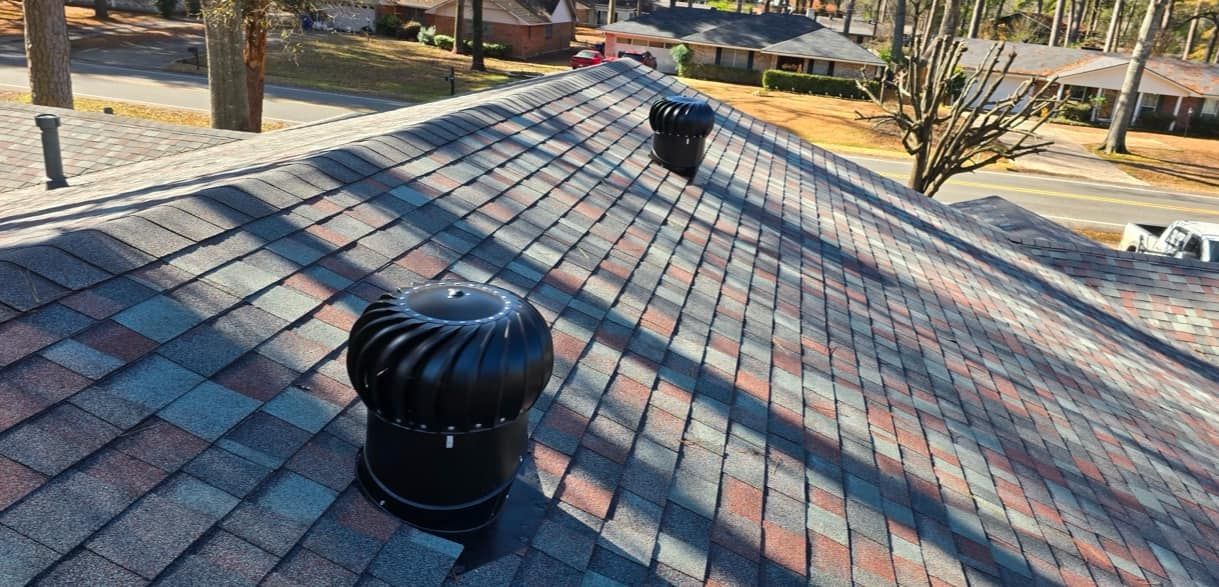 A roof with a lot of shingles and chimneys on it.