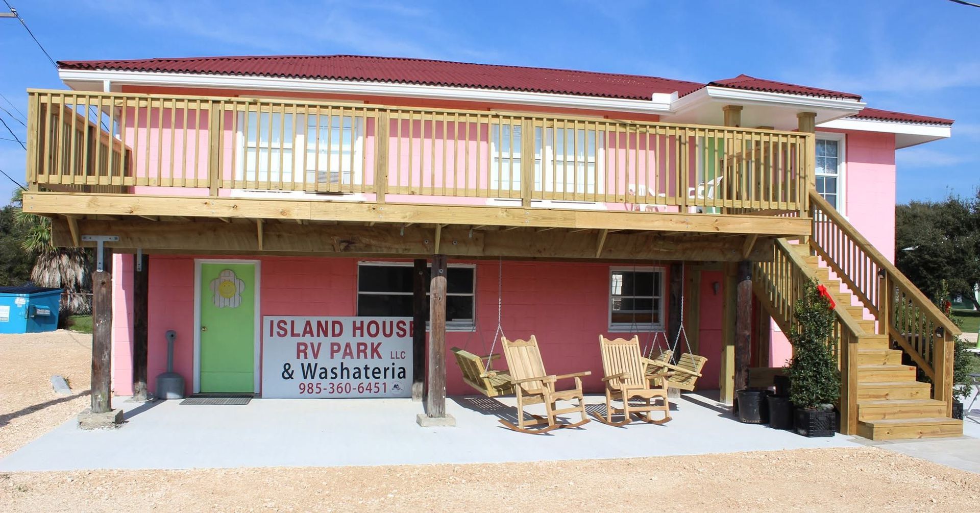 Pink Island House RV Park & Motel exterior with wooden decks and stairs.