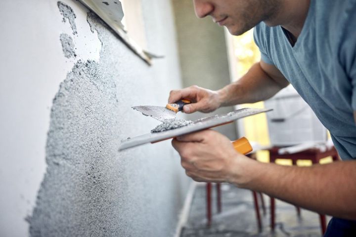Applying a smooth concrete finish to an interior wall.