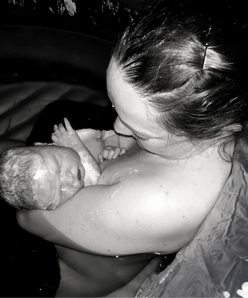 Newborn baby lying on mother's chest in skin-to-skin contact shortly after birth