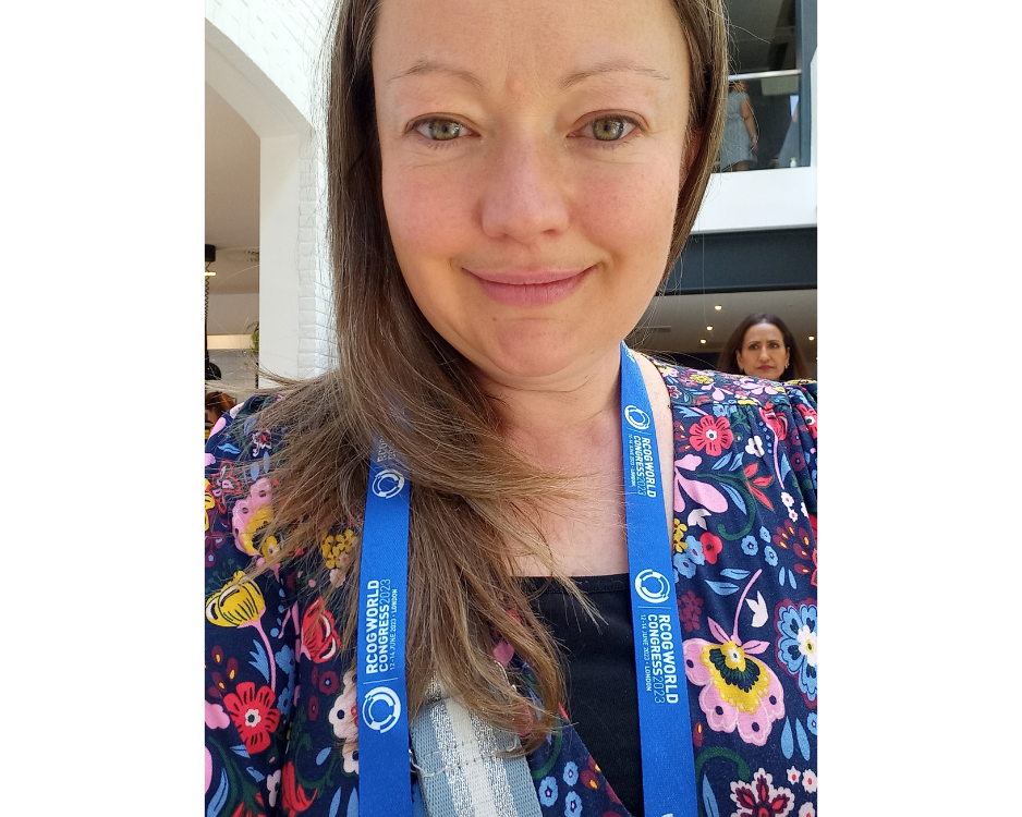 Lisa attending the RCOG World Congress, wearing a delegate lanyard and smiling