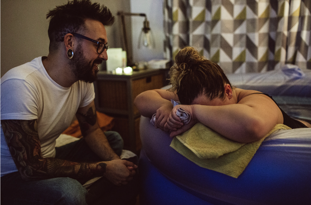 Couple during active labour at home in birth pool, shared as a positive birth story