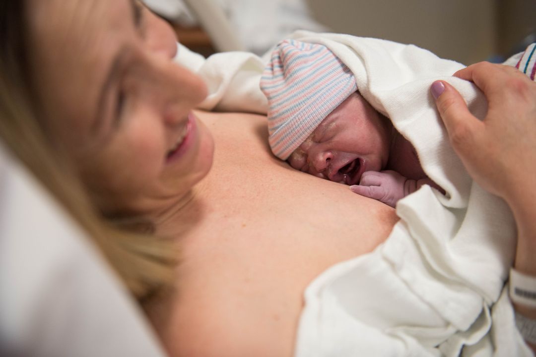 Mother with her Newborn Baby New mother holding her newborn baby in a positive birth experience supported by a doula. – what’s a doula?
