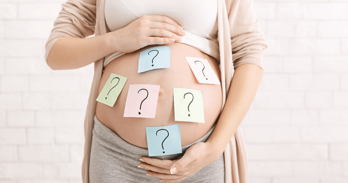Pregnant woman with question mark notes on belly, symbolising questions about where to give birth in