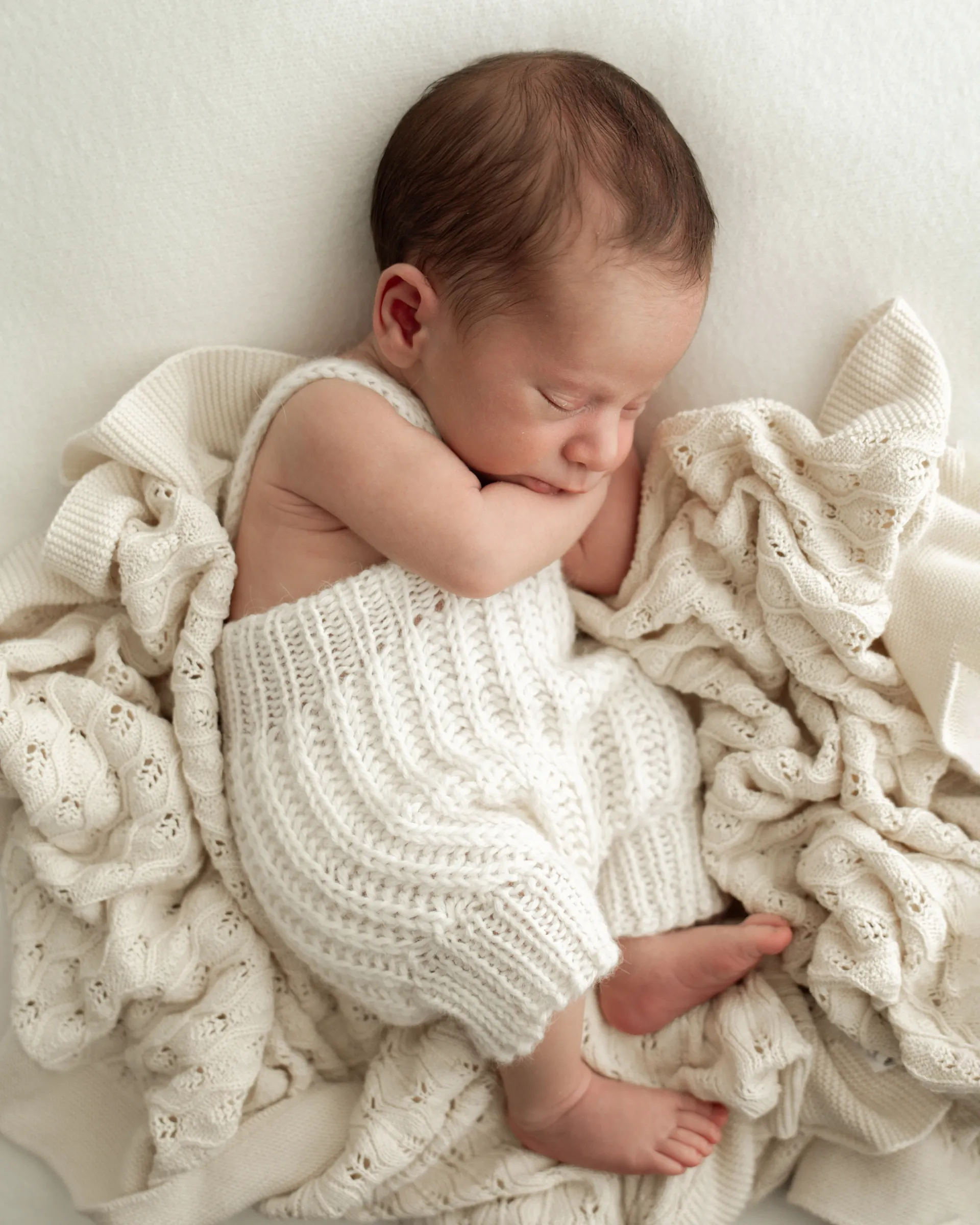 Close-up of a sleeping newborn wrapped in a soft blanket