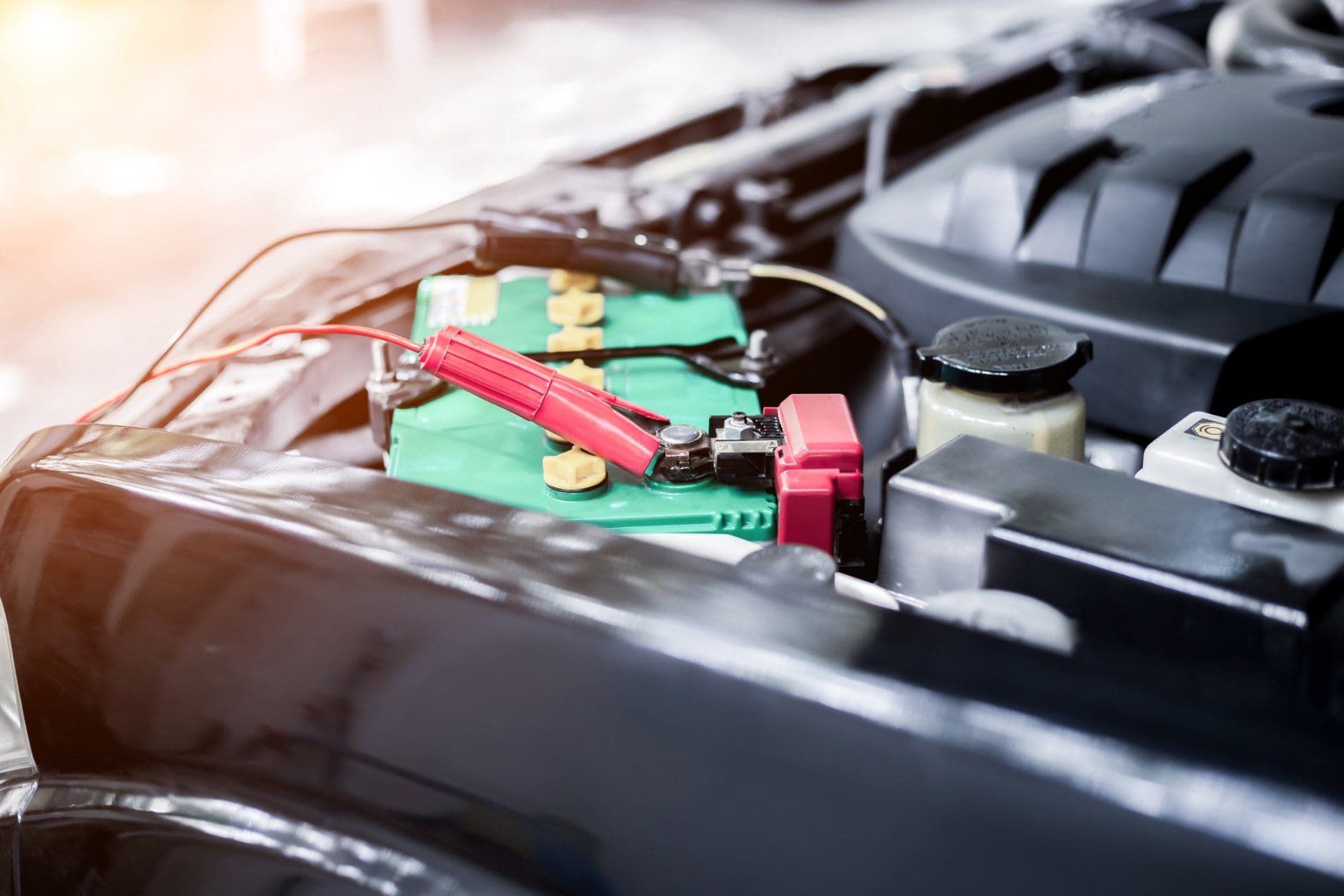 A Car Battery is Being Charged With a Charger Under the Hood — Waring's Auto Electrical in South Geelong, VIC
