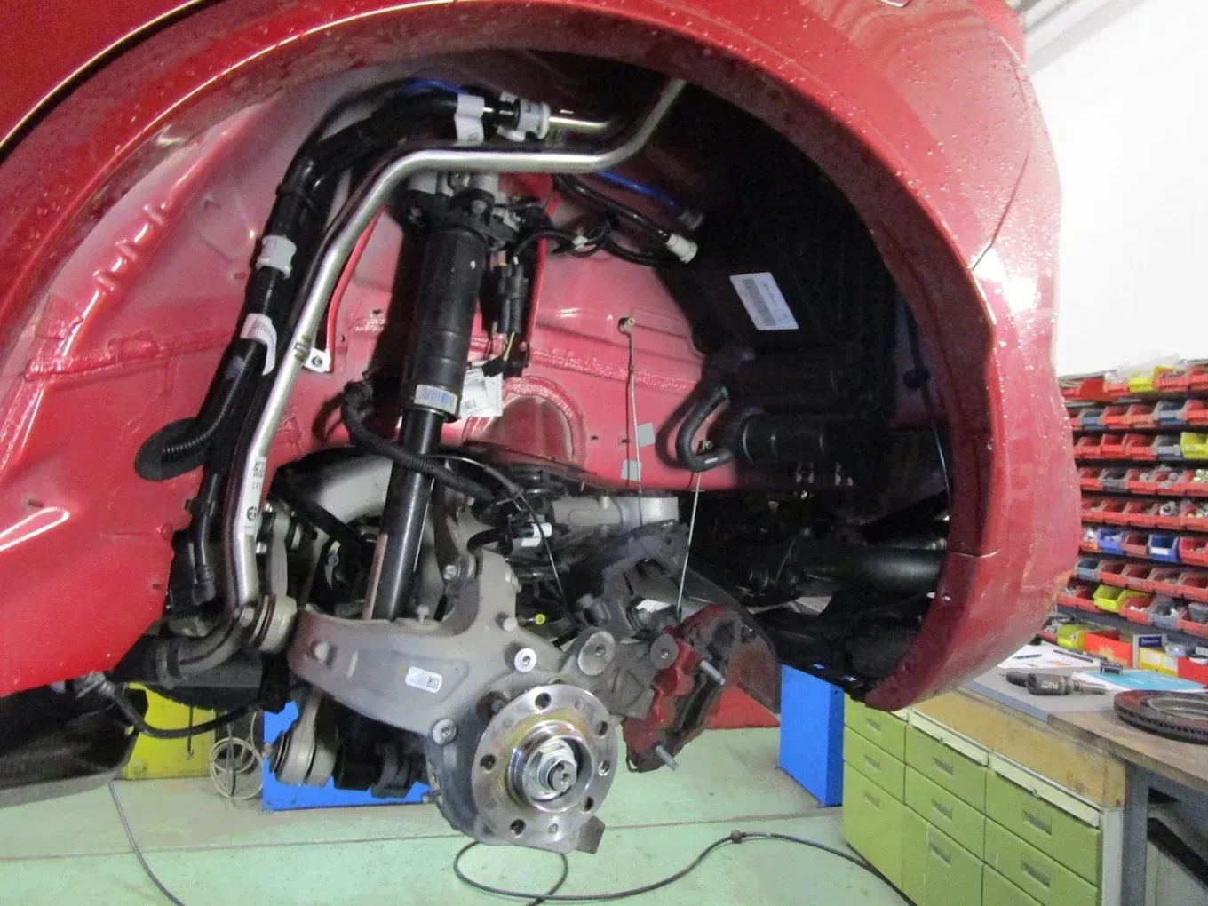 Une voiture rouge est en cours de réparation dans un garage
