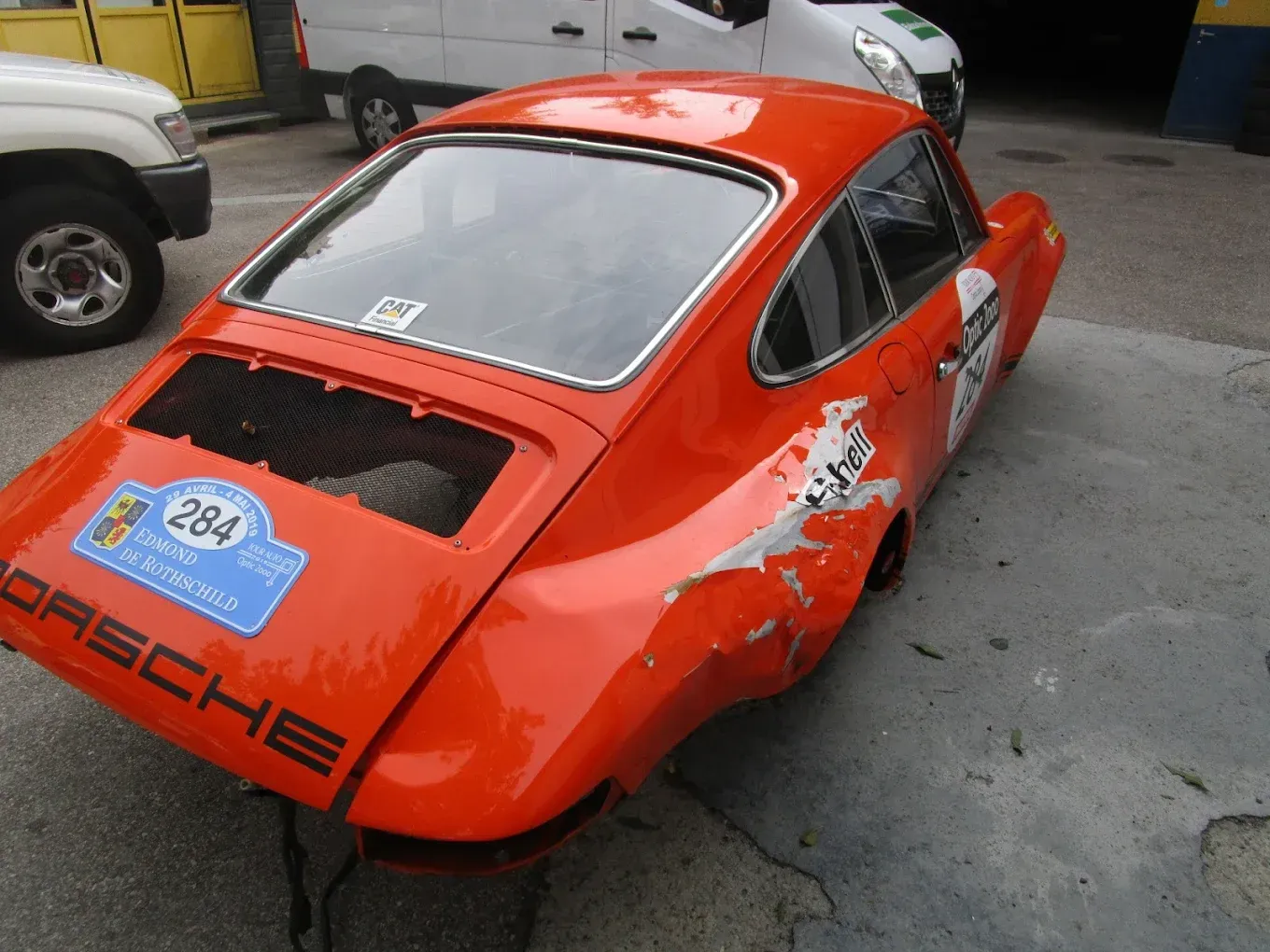 Une Porsche orange est garée sur un parking