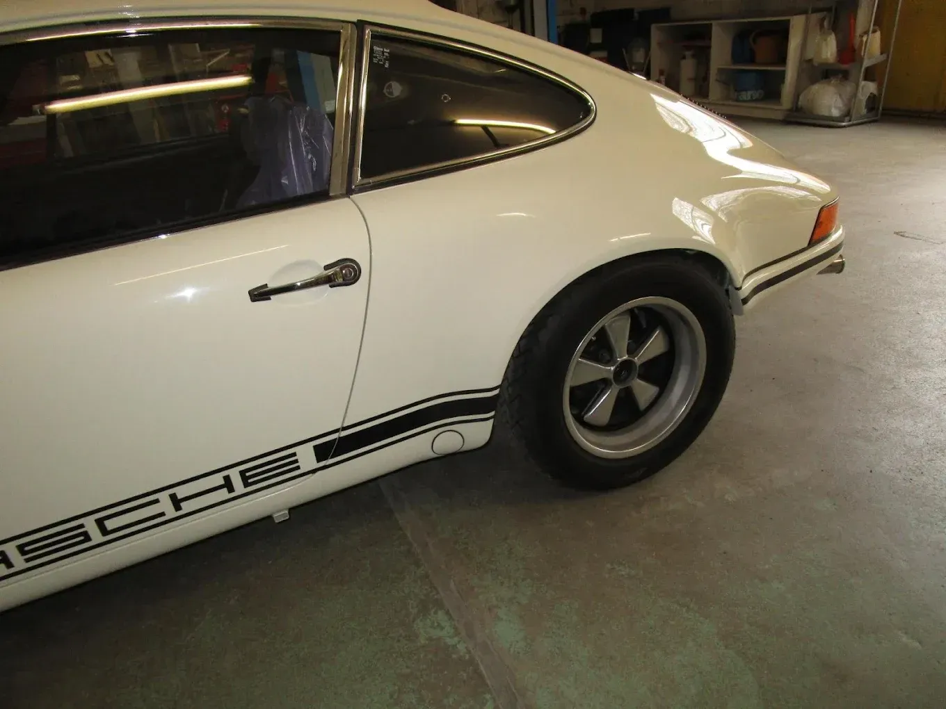 Une Porsche blanche est garée dans un garage