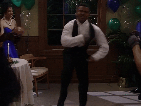 Carlton from Fresh Prince of Bel Air in formal wear dances enthusiastically at a party, surrounded by guests and balloons.