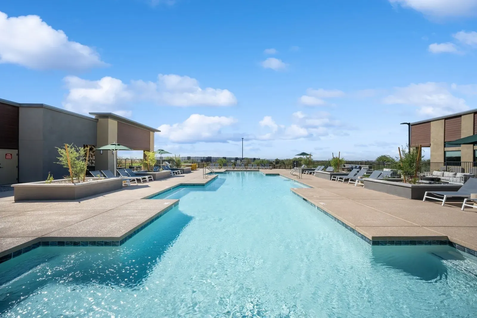 Relax and unwind by our sparkling outdoor swimming pool, complete with comfortable lounge chairs and shaded umbrellas.