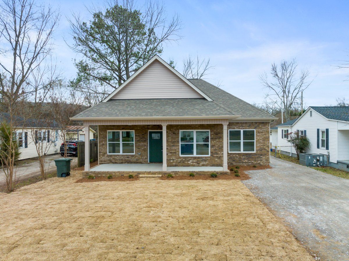 Front exterior of a completed Mims Custom Home Construction build — brick, covered porch, architectural shingles.](