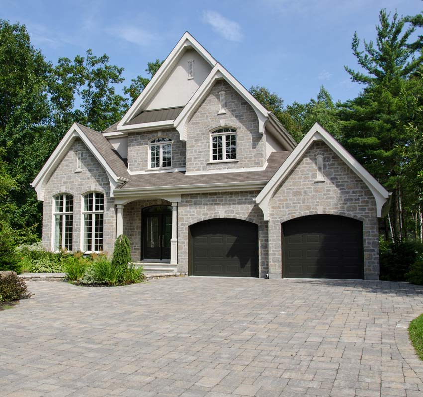 a large brick house with two black garage doors