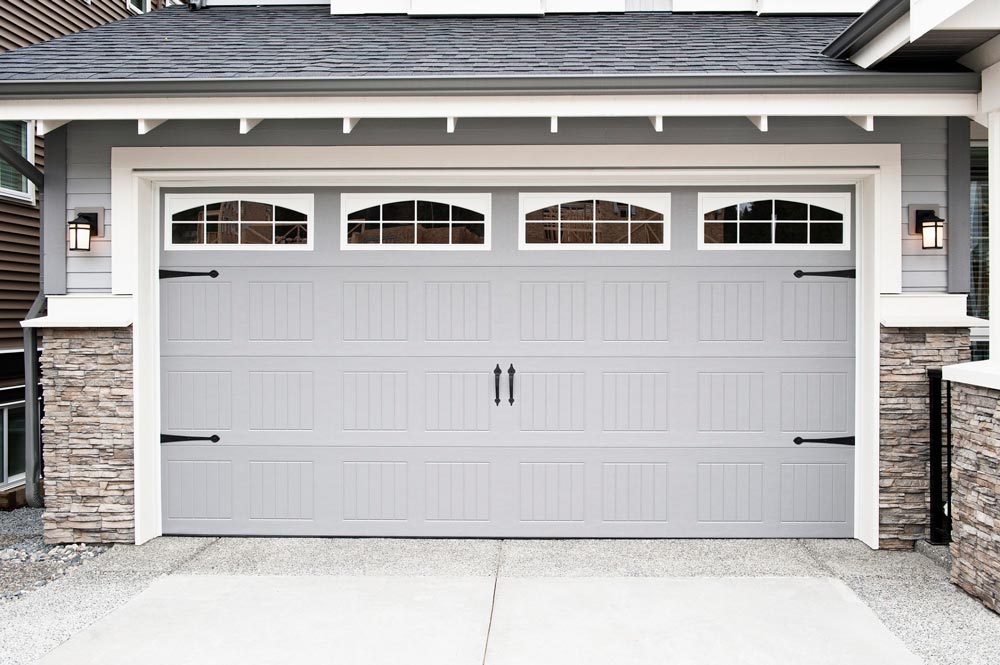 a gray garage door is sitting in front of a house .