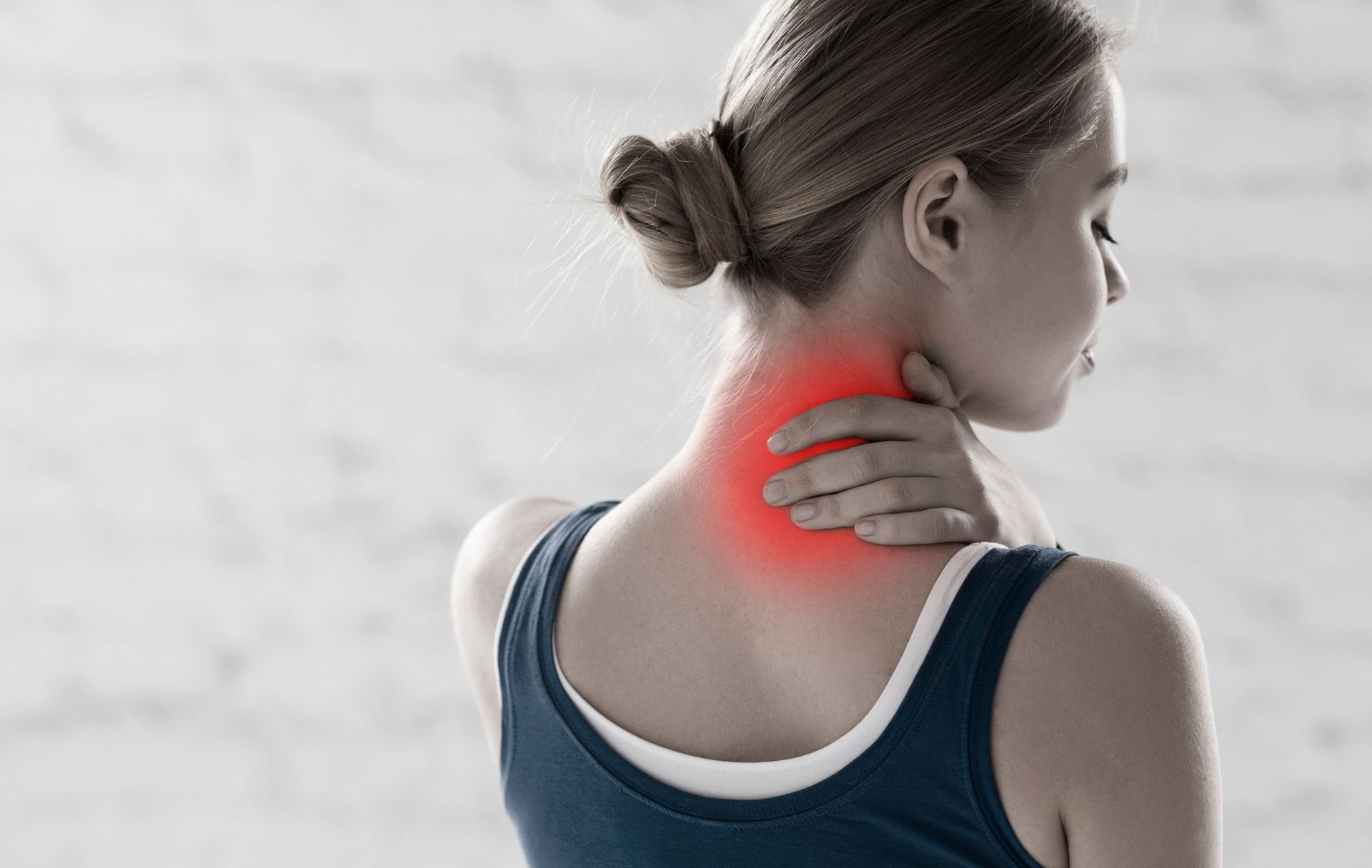 Professional sportswoman feeling pain in her neck in a gym.