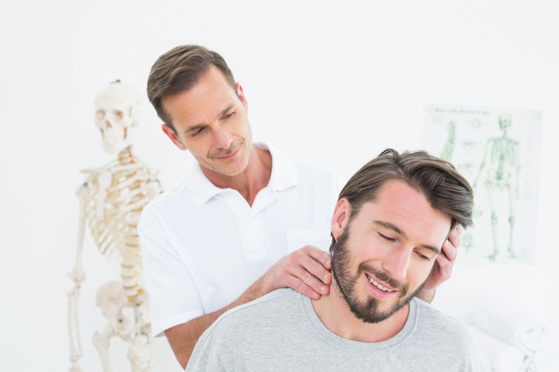 Male chiropractor doing neck adjustment to a male patient.